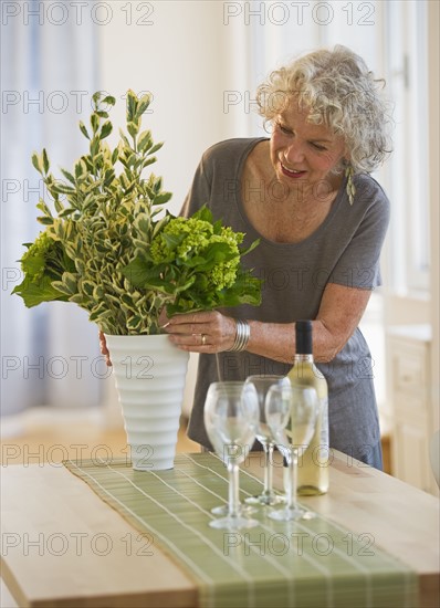 Woman arranging flowers in a vase. Photo : Daniel Grill