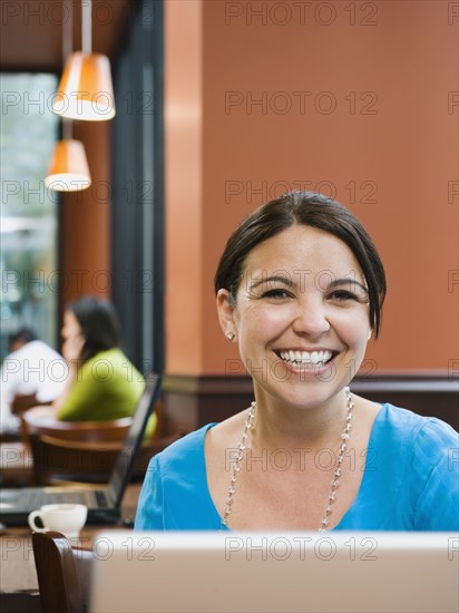 Smiling woman sitting at table in restaurant. Photo. Erik Isakson