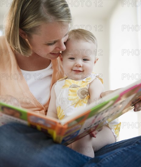 Mother reading book to her baby daughter. Photo : Jamie Grill