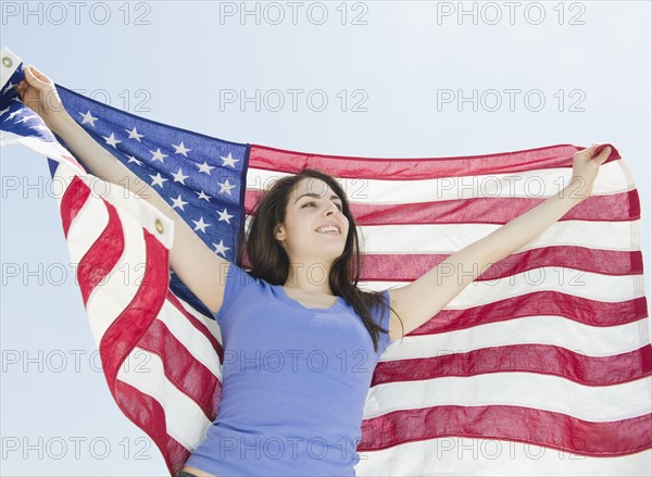 Woman holding American flag. Photo : Jamie Grill