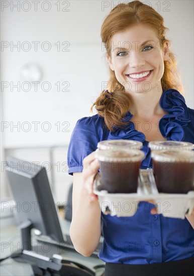 Businesswoman holding a tray of coffee. Photo : Jamie Grill