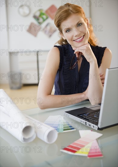 Pretty businesswoman sitting at her desk. Photo : Jamie Grill