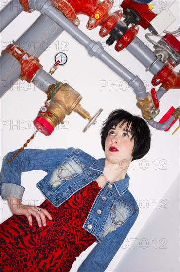 Woman standing beside pipes. Photo : Daniel Grill