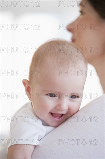 Baby being held by mother.