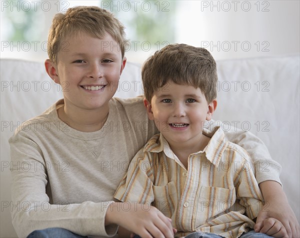 Brothers sitting on couch together.