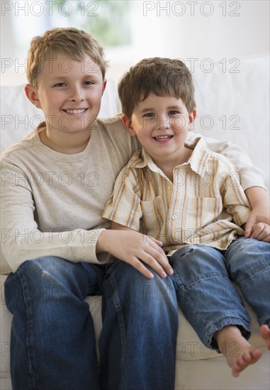 Brothers sitting on couch together.