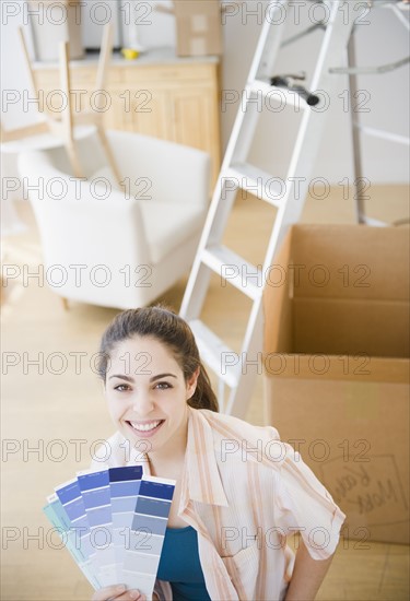 Woman holding paint swatches. Photo. Jamie Grill