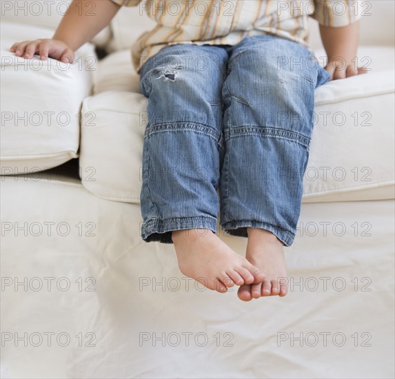 Young boy sitting on couch.