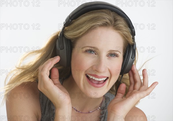 Blond woman listening to music with headphones.