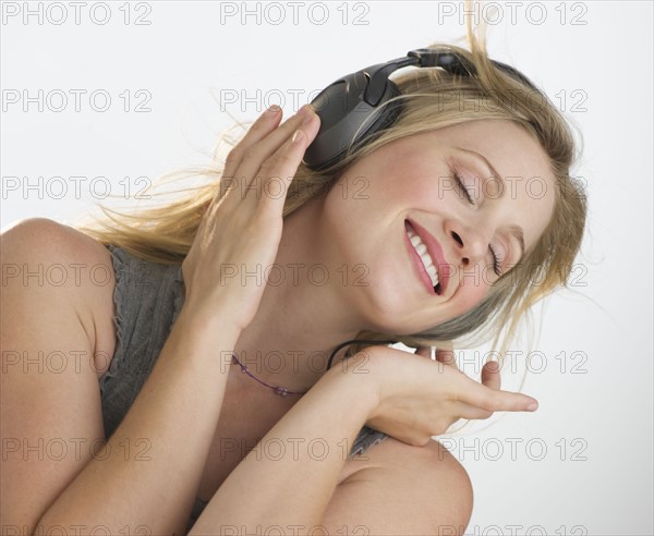 Blond woman listening to music with headphones.