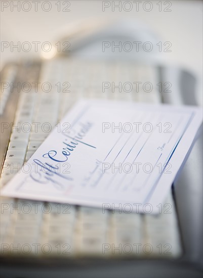 Gift certificate on computer keyboard. Photo : Jamie Grill