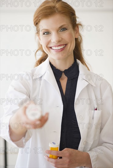 Pharmacist holding bottle of prescription medication. Photo. Jamie Grill