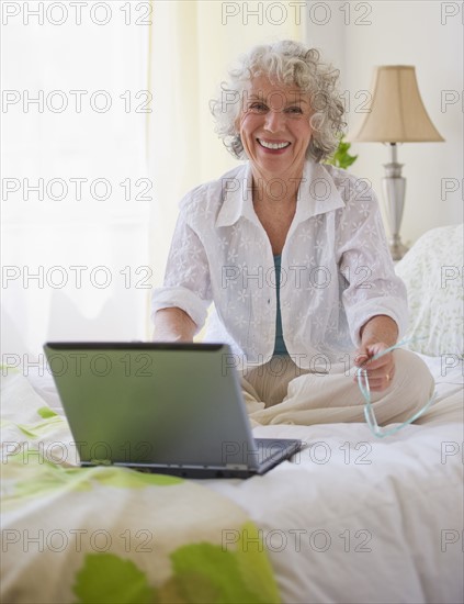 Cheerful woman looking at laptop. Photo : Daniel Grill