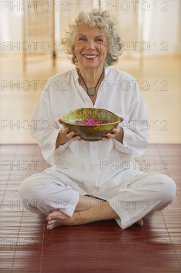 Woman holding bowl of flower petals. Photo : Daniel Grill