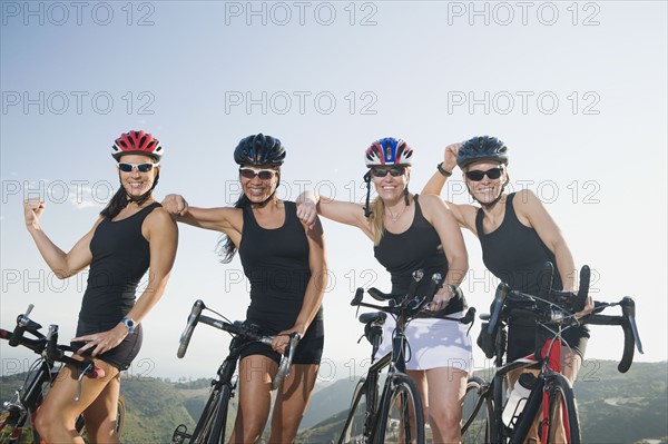 Four women standing beside their bicycles. Photo. Erik Isakson