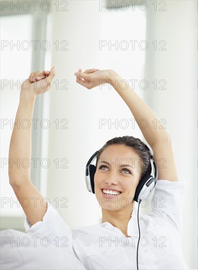 Woman listening to music on headphones. Photo : momentimages