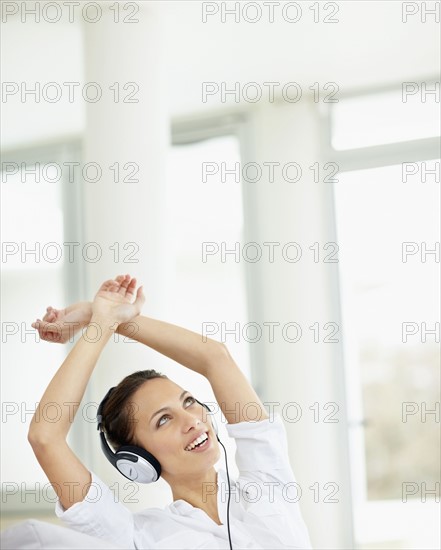 Woman listening to music on headphones. Photo : momentimages