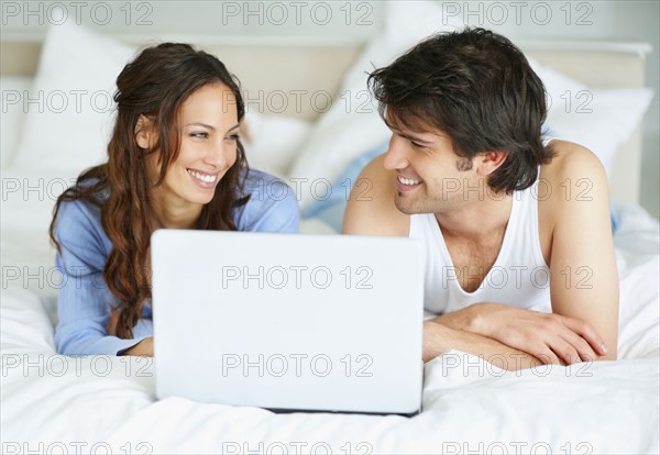 Couple looking at laptop together. Photo : momentimages