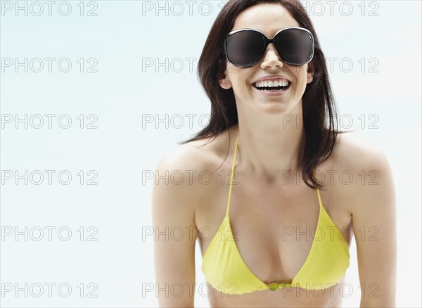 Brunette wearing bikini and sunglasses. Photo : momentimages