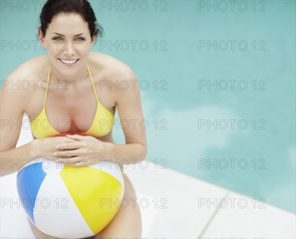 Attractive brunette holding a beach ball. Photo. momentimages