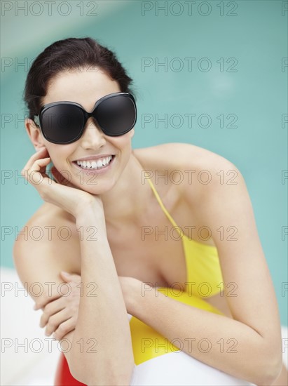 Attractive brunette wearing sunglasses and bikini. Photo. momentimages