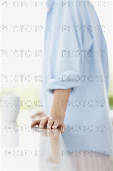 Woman leaning on kitchen counter. Photo. momentimages