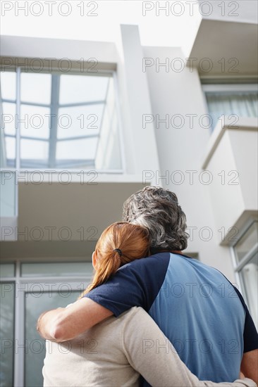 Couple looking at the their home. Photo : momentimages
