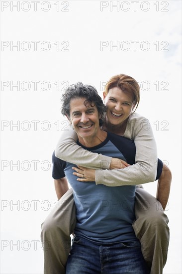 Man giving woman a piggy back ride. Photo. momentimages