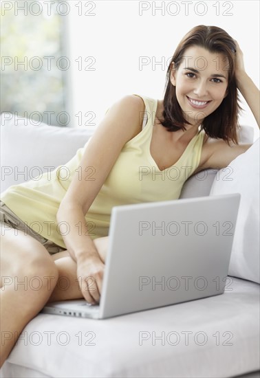 Smiling brunette woman browsing the internet. Photo. momentimages