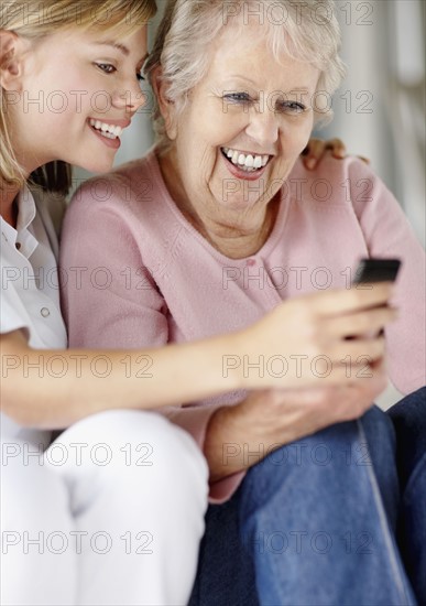 Nurse helping woman send a text message. Photo : momentimages