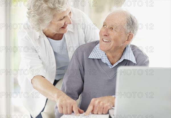 Senior couple doing paperwork together. Photo : momentimages