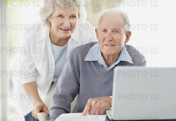 Senior couple doing paperwork together. Photo : momentimages