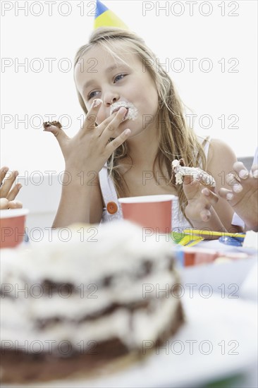 Young girl eating birthday cake. Photo. momentimages