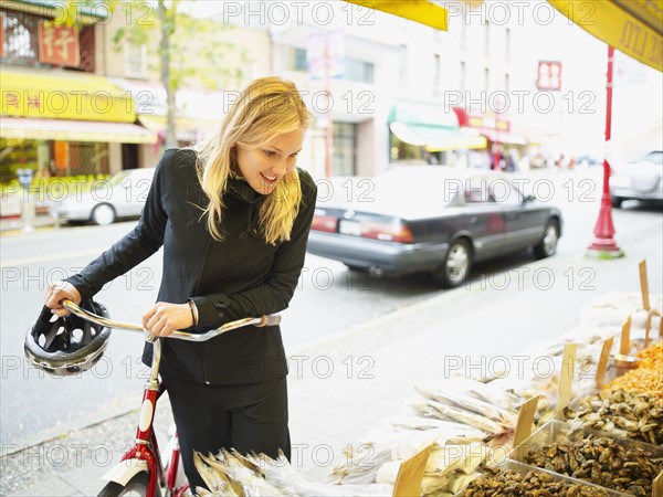 Cyclist looking at display of fish. Photo : John Kelly