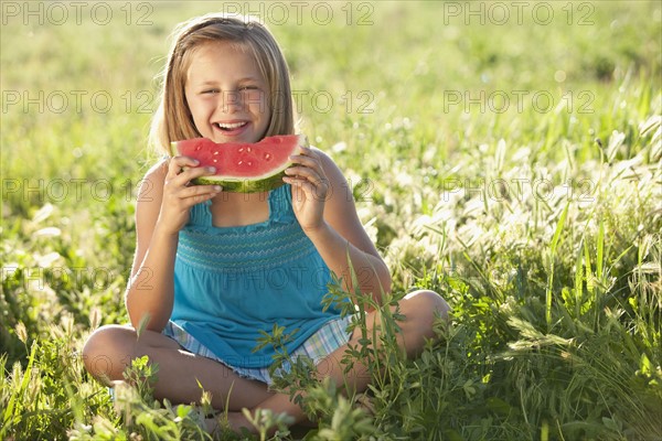 Young girl eating a slice of watermelon. Photo : Mike Kemp