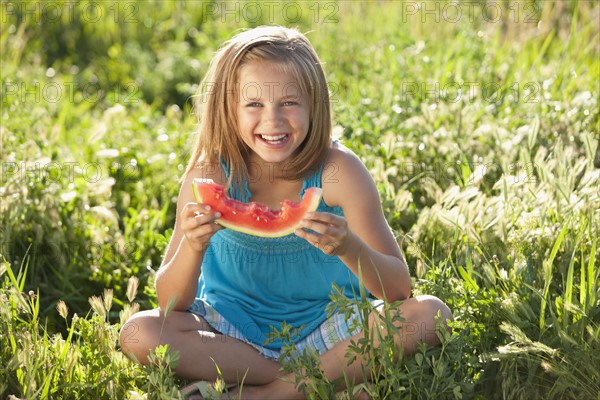 Young girl eating a slice of watermelon. Photo : Mike Kemp