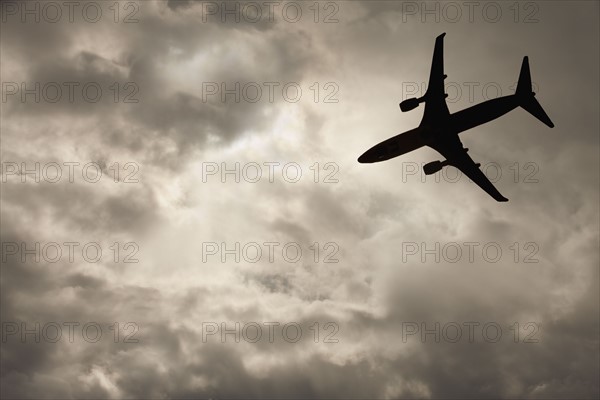 Commercial jet in cloudy sky. Photo. Mike Kemp