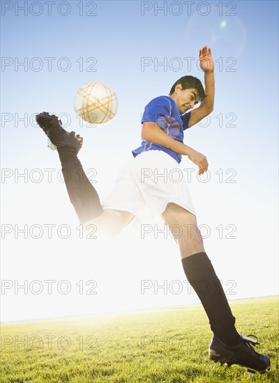 Soccer player jump kicking. Photo : Mike Kemp