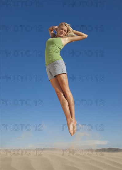 Woman jumping in the desert. Photo : Mike Kemp