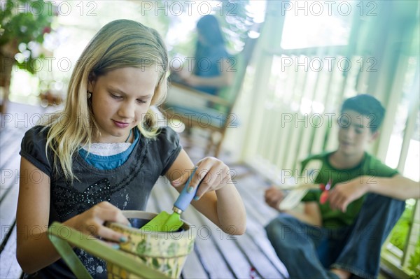 Young girl potting a plant. Photo : Tim Pannell