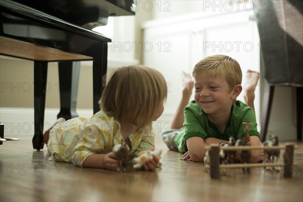 Brother and sister playing with toy animals. Photo : Tim Pannell