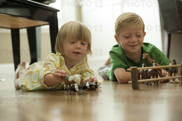 Brother and sister playing with toy animals. Photo : Tim Pannell