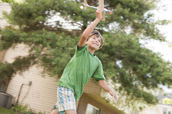 Young boy running with toy airplane. Photo. Tim Pannell