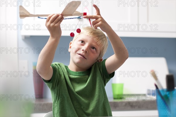 Young boy playing with toy airplane. Photo. Tim Pannell