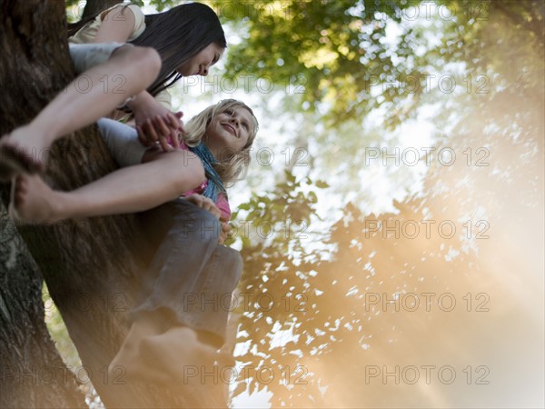 Two girls sitting in a tree. Photo. Tim Pannell