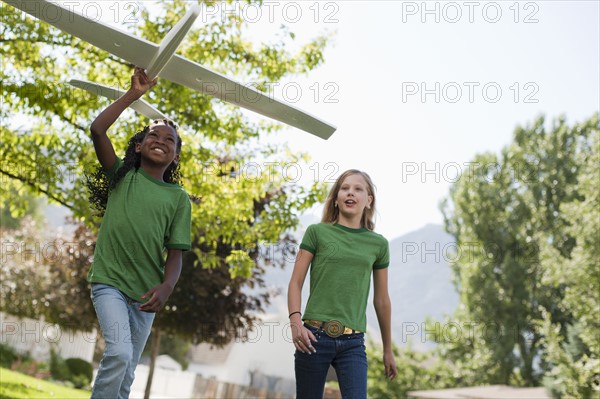 Two girls playing with toy airplane. Photo. Tim Pannell