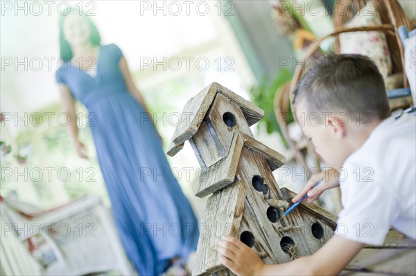 Young boy painting a birdhouse. Photo : Tim Pannell