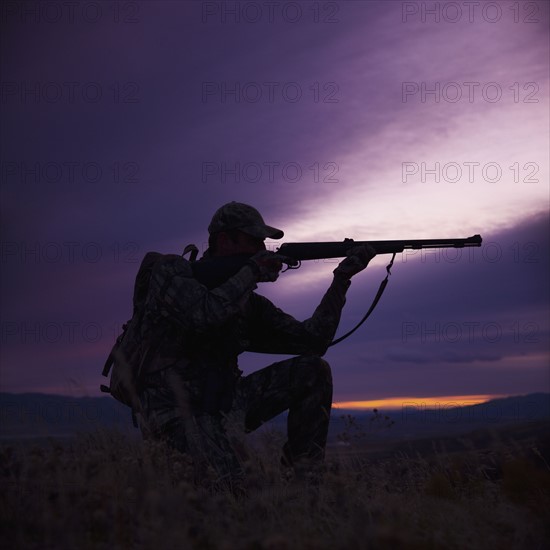 Hunter pointing his rifle. Photo. Mike Kemp