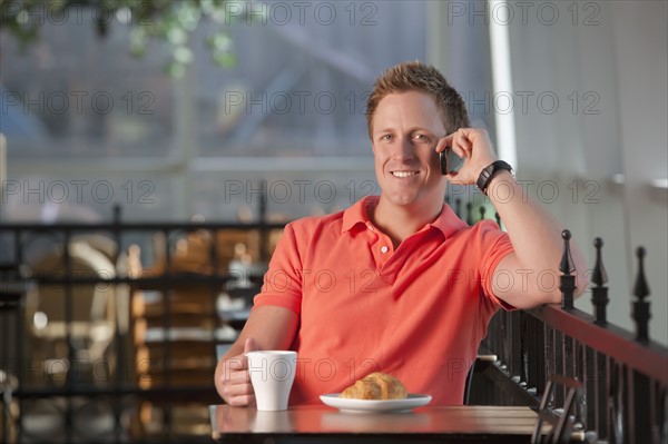 Man sitting on patio at cafe. Photo : Dan Bannister