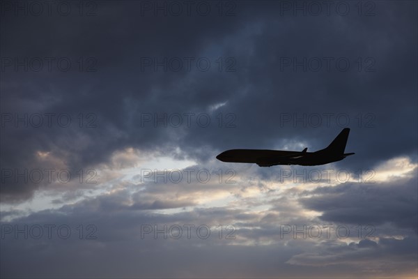 Commercial jet in cloudy sky. Photo. Mike Kemp